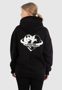Hoodie noir avec un design graphique blanc : forme de cœur avec un globe à l'intérieur et le texte "SMILODOX", tissu doux, coupe décontractée, manches longues.