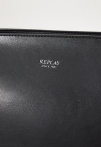 Zwarte leren portemonnee met een gladde textuur, met een reliëf "REPLAY" logo en de tekst "SINCE 1981" in zilver.