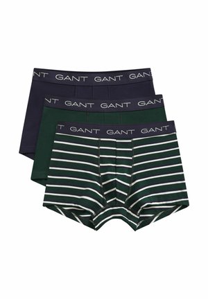 Trois paires de boxers pour hommes empilés, un bleu marine, un vert foncé et un vert à rayures blanches horizontales, tous avec le logo GANT sur la ceinture.