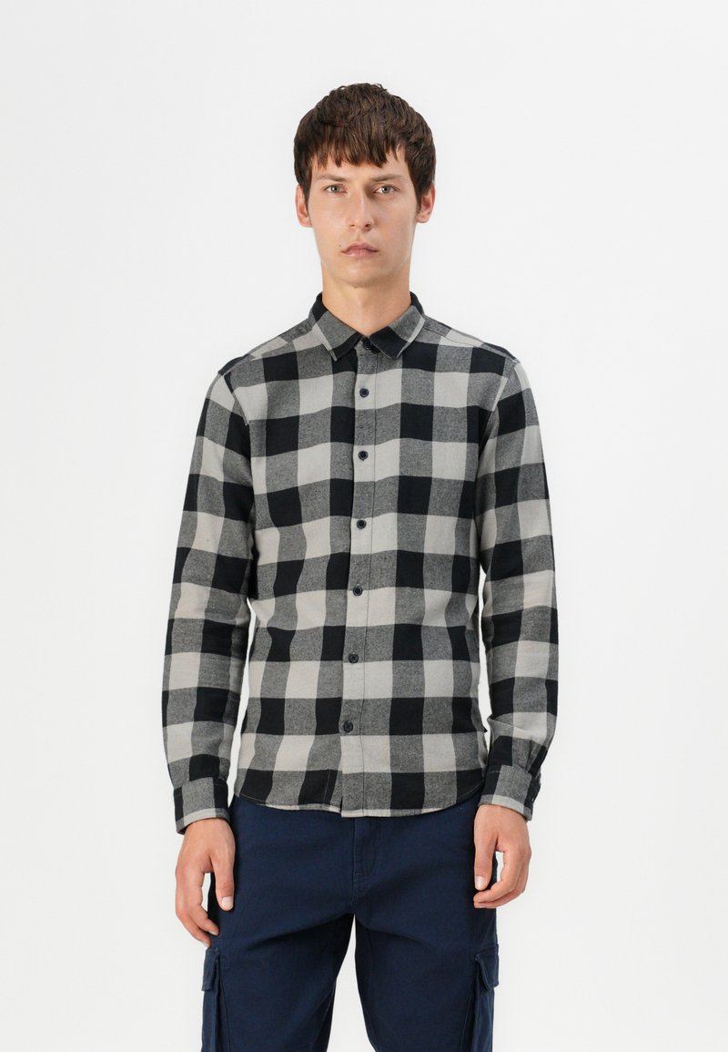 Camisa de cuadros negra y gris con cuello, mangas largas y dobladillo recto. La textura de la tela parece suave y ligera.