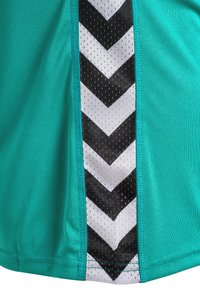 Kortärmad turkos träningsskjorta med en sidpanel i svart-vitt zigzag-mönster och andningsbar meshstruktur.