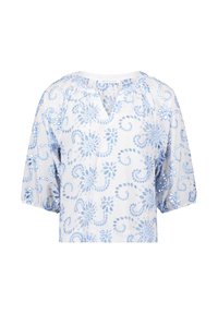 Witte blouse met lichtblauwe bloemenborduursels, korte puff mouwen en een V-halslijn. Kenmerkt zich door een ingewikkeld gestikt patroon en opengewerkte accenten.