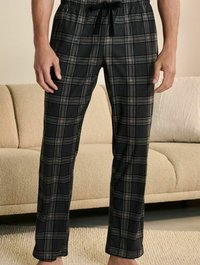 Black and green plaid pajama pants with an elastic waistband and drawstring. Cotton fabric, relaxed fit, smooth texture, and no visible pockets.