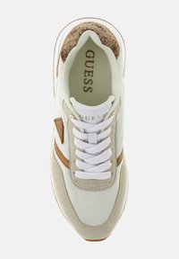 Baskets blanches et beiges avec un accent marron texturé, fermeture à lacets et semelle intérieure coussinée. Présente un logo "Guess" sur la languette.