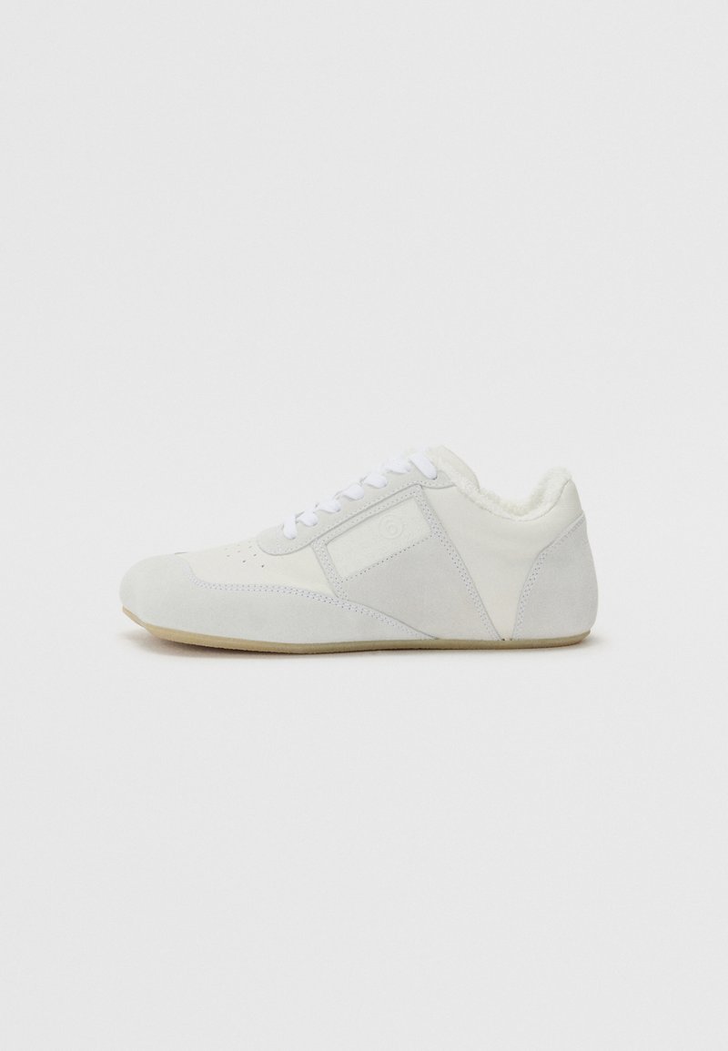 Bela teniska iz usnja in semiša z gladko obdelavo, ki ima oblazinjeno notranjost, ravne vezalke in subtilne šivane podrobnosti.