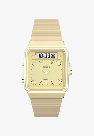 Montre en quartz dorée avec un cadran carré, affichage numérique, cadran jaune, accents argentés et un bracelet en métal doré texturé.