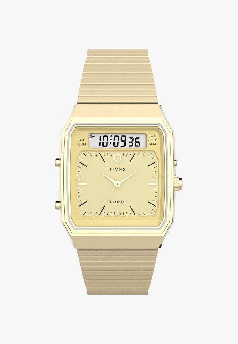 Kuldtooni kvarts kell ruudukujulise näo, digitaalse ekraani, kollase dials, hõbedaste aksessuaaridega ja tekstureeritud kuldmetallist rihmaga.