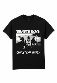 Camiseta de algodón negra con un gráfico de tres figuras en blanco y negro, con el texto "BEASTIE BOYS" y "CHECK YOUR HEAD" en una fuente blanca en negrita.