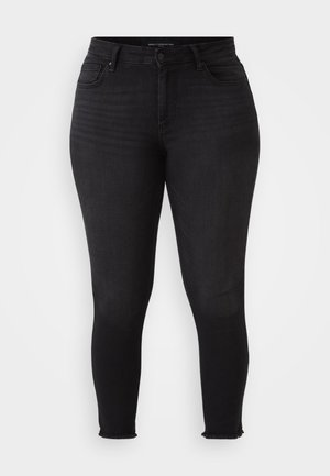 Black skinny jeans with a high waistband, made from stretchy denim. Features front pockets and frayed hems. Smooth texture with subtle fading.