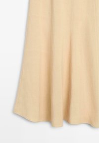 Beige A-line skirt section showing smooth fabric with subtle vertical seams and a slightly flared hem.