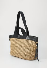 Bolsa de palha trançada com detalhes em couro preto. Apresenta alças duplas de tecido e um formato estruturado, adequada para uso diário.