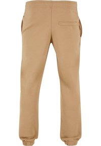 Beige Sweatpants aus weichem Stoff mit elastischem Bund, seitlichen Taschen und einer rückseitigen Patttasche; tapered Bündchen an den Knöcheln.