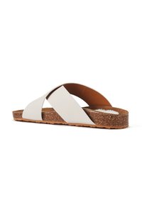 Korksohlen-Sandalen mit überkreuztem Riemendesign aus weichem weißen Synthetikmaterial und braunem, wildlederähnlichem Fußbett.
