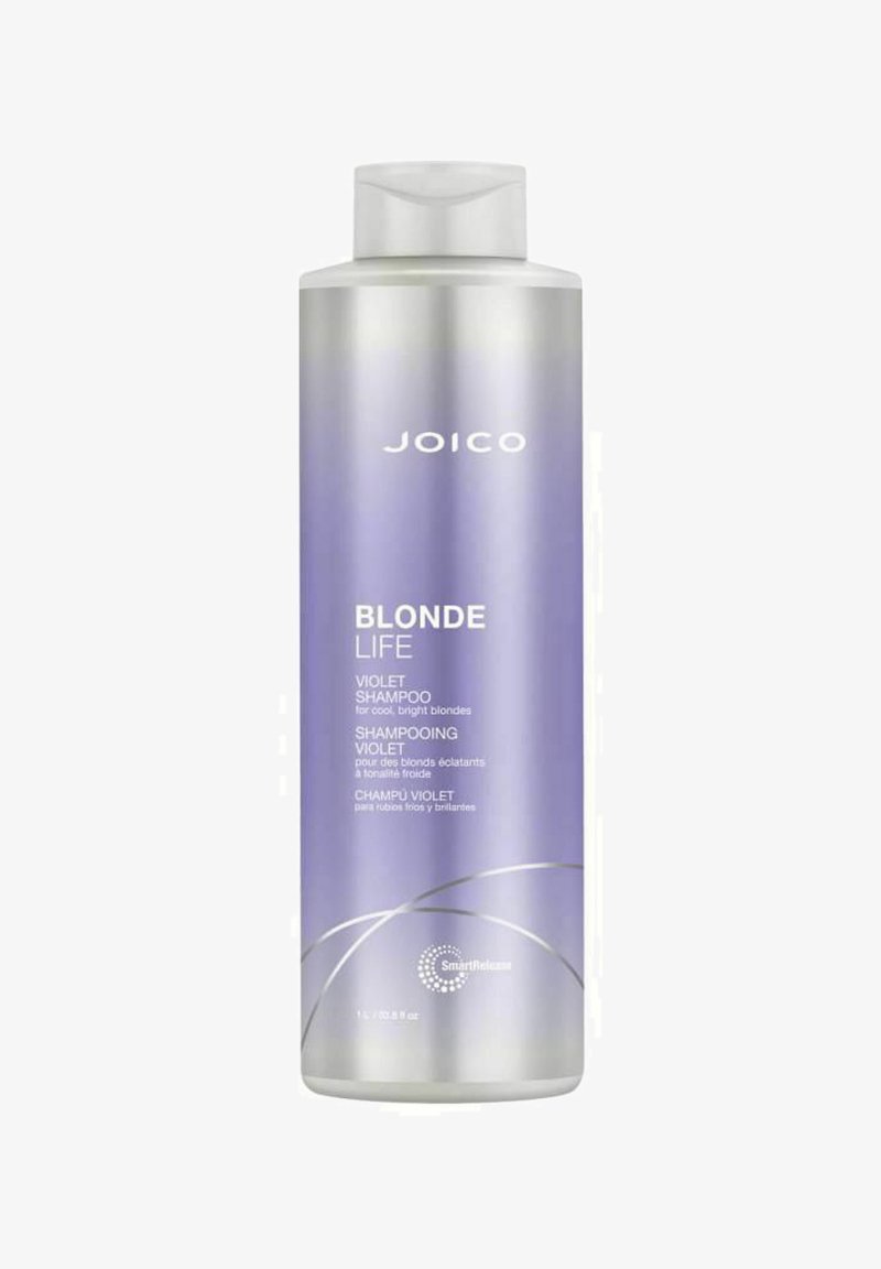 Lila shampoo i en klar, cylinderformad flaska med en gradient från silver till lavendel. Med vit text och en silvervirveldesign.