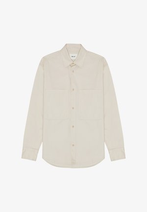 Lichtbeige langemou shirt gemaakt van zachte stof, voorzien van een puntige kraag, knopen aan de voorkant en twee borstzakken. Rechte onderkant.