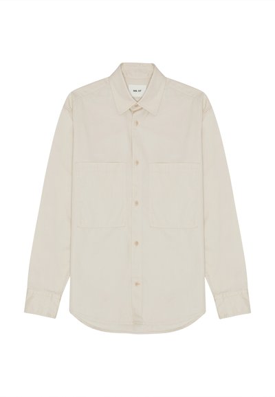 Lys beige langærmet skjorte lavet af blødt stof, der har en spidse krave, forreste knapper og to brystlommer. Lige nederste kant design.