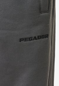 Pegador LOGO WIDE PANTS - Pantalones deportivos - washed anthracite