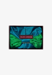 Turban in pura seta con una combinazione di colori blu e verde, presentato in una scatola con etichetta di marca e testo dorato.