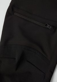 Zwarte sportbroek met een ritszak, een gladde textuur, en contrasterende paneelwerking met een subtiel geometrisch patroon.
