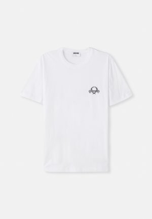 T-shirt en coton blanc avec un petit graphique de crabe noir et des éléments décoratifs sur la poitrine. Manches courtes et col rond.