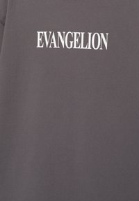 Huppari, jossa on rohkealla valkoisella tekstillä "EVANGELION". Kangas näyttää pehmeältä, tasaiselta ja mukavalta.