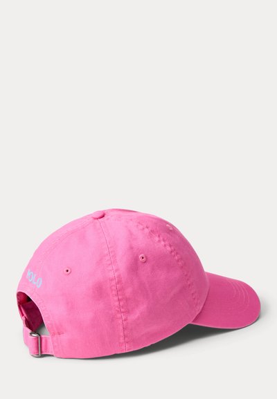 Φωτεινό ροζ ρυθμιζόμενο καπέλο μπέιζμπολ με καμπύλη γείσο, λουρί με μεταλλικό πόρπη και μικρό μπλε κεντημένο κείμενο κοντά στο πίσω μέρος.
