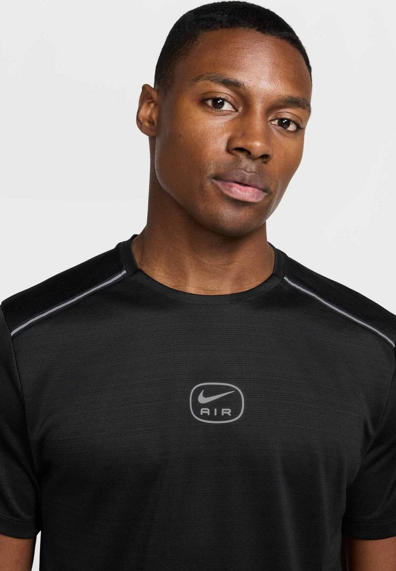 T-shirt sportivo Nike Air nero, realizzato in un tessuto texturizzato, con scollatura rotonda e dettagli riflettenti sulle spalle. Logo posizionato al centro.