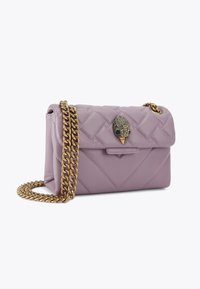 Borsa in pelle lavanda trapuntata con tracolla in catena dorata e chiusura decorativa caratterizzata da un design di uccello. Forma rettangolare compatta.