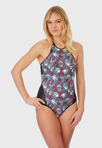 Maillot de bain noir et à motifs colorés avec un design à col haut, motifs de feuilles tropicales en vert, blanc et rose, avec des accents noirs.