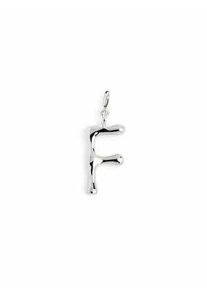 Pendentif en métal argenté en forme de lettre "F", avec un design organique et lisse, aux bords arrondis et à la finition polie.