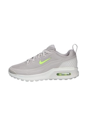 Baskets Nike Air Max gris clair avec swoosh vert néon, coussinet d'air visible dans la semelle et languette en tissu au talon.