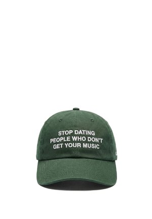 Grøn baseballkasket med hvidt broderet tekst: "STOP MED AT DATE FOLK, DER IKKE FORSTÅR DIN MUSIK," forfra på hvid baggrund.