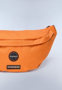 Borsello in tessuto arancione con design arrotondato, caratterizzato da un logo circolare nero e un'etichetta testuale nera a contrasto. Texture liscia, chiusura con zip.