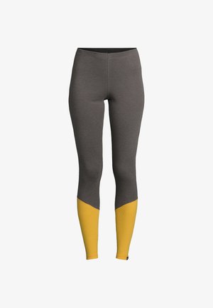 Leggings gris au design ajusté, avec un accent jaune au niveau des jambes inférieures et un matériau texturé au niveau des chevilles.