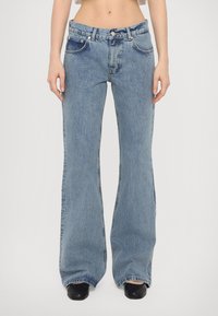 Ljus tvättade denim jeans med utsvängda ben och hög midja, med fem fickor, kontrasterande sömmar och subtil textur.