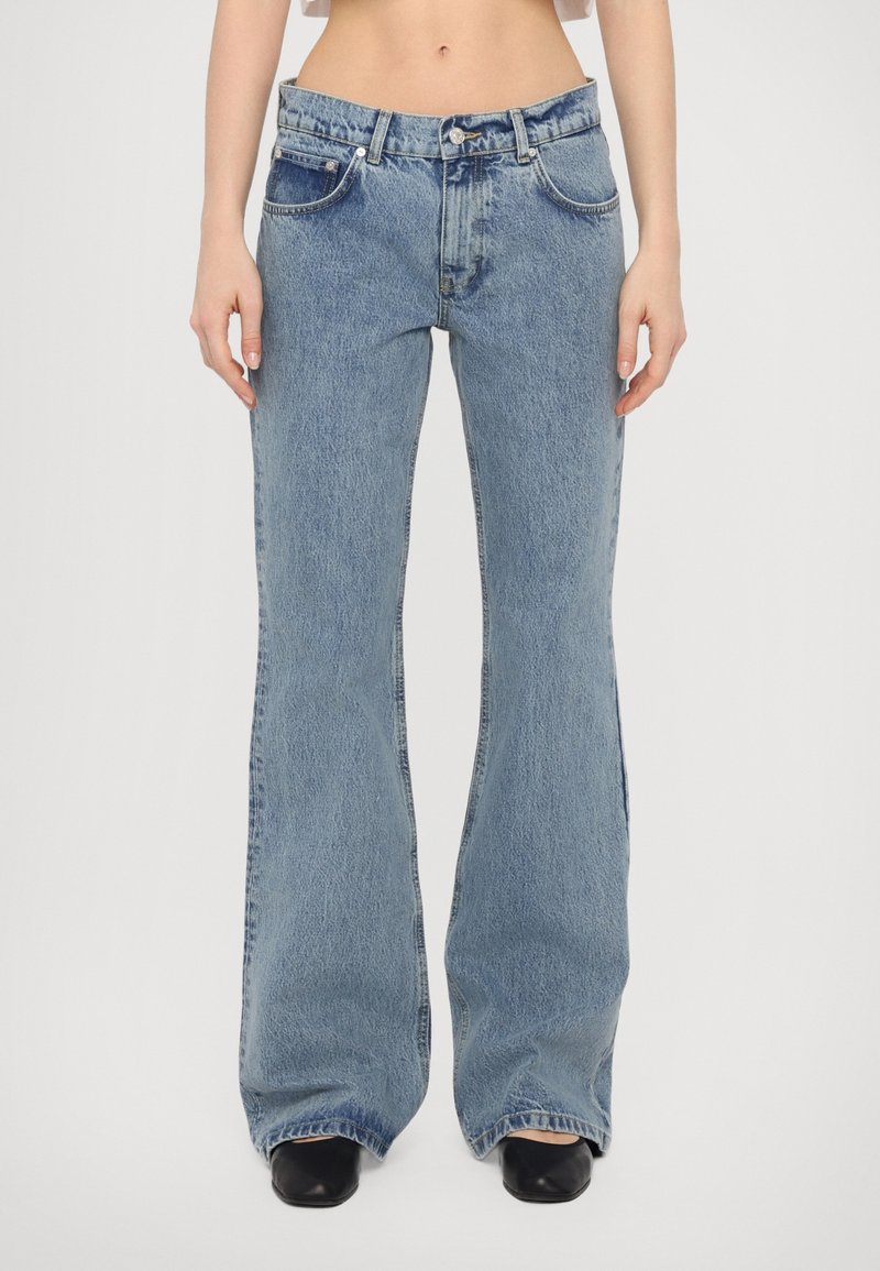 Ljus tvättade denim jeans med utsvängda ben och hög midja, med fem fickor, kontrasterande sömmar och subtil textur.