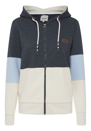 Hoodie zippé bleu marine et crème avec des panneaux bicolores, doté d'une capuche, de cordons de serrage et d'un patch en cuir marron.