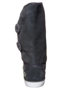 Botte en daim noir avec une forme incurvée, deux boutons décoratifs sur le côté et une semelle en caoutchouc blanche. Présente un petit logo près de la base.