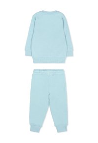 Pantaloni felpati azzurro chiaro e maglia a maniche lunghe coordinata, realizzati in tessuto morbido, con polsini a coste e vita elastica.