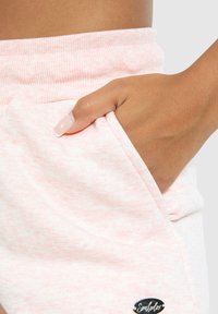 Roze, gestructureerde stoffen short met een elastische tailleband en zijzakken. Bevat een klein merkembleem bij de zoom.