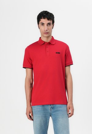 Rode polo shirt van katoen, met een klassieke kraag, korte mouwen en een klein zwart logo-detail op de borst.