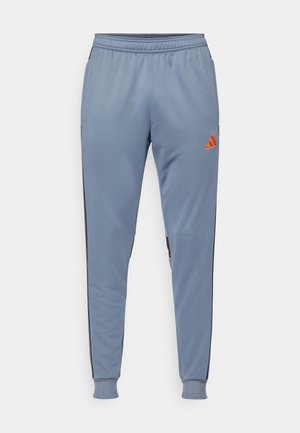 Lichtblauwe sportbroek met een getailleerde pasvorm, zwarte zijpanelen en een oranje logo op het bovenbeen, gemaakt van een gladde, ademende stof.