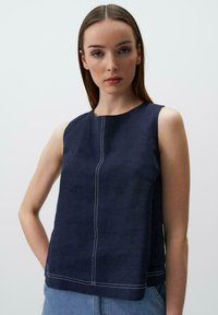 Top senza maniche in lino blu navy con scollatura rotonda, taglio dritto e dettagli di cucitura bianca al centro. Texture liscia e design casual.