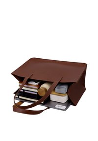 Sac cabas en cuir marron ouvert montrant un contenu organisé comprenant un ordinateur portable, des cahiers, un téléphone, une bouteille d'eau et de petites boîtes de rangement.