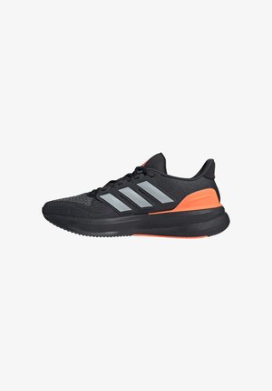 Zapatilla de running negra y naranja con tres rayas plateadas en el lateral, suela acolchada y parte superior de malla para mayor transpirabilidad.
