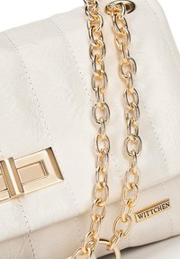 Bolso de mano de piel sintética blanca con correa de cadena dorada y acentos metálicos. Presenta un cierre rectangular y una placa de marca grabada.