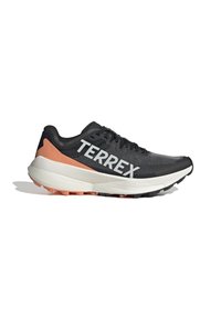 Crne atletske cipele s mrežastim gornjim dijelom, narančasti akcent na peti, bijeli "TERREX" logo i debeli, višestruko teksturirani potplat.