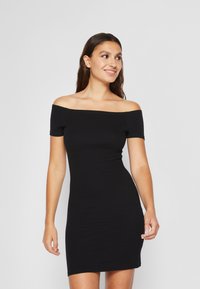 Abito nero off-the-shoulder con design aderente, realizzato in tessuto elasticizzato. Maniche corte e una superficie liscia con una silhouette semplice e slanciata.