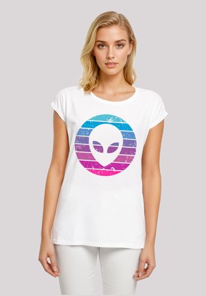 White short-sleeve t-shirt featuring an alien graphic in blue and pink stripes inside a circular design, with a distressed texture.