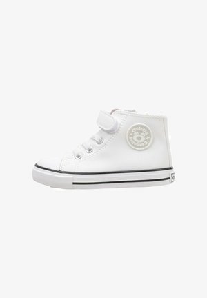 Zapatilla blanca de caña alta con parte superior sintética lisa, suela de goma negra, cierre con cordones y tira de Velcro, con un logo circular en el lateral.